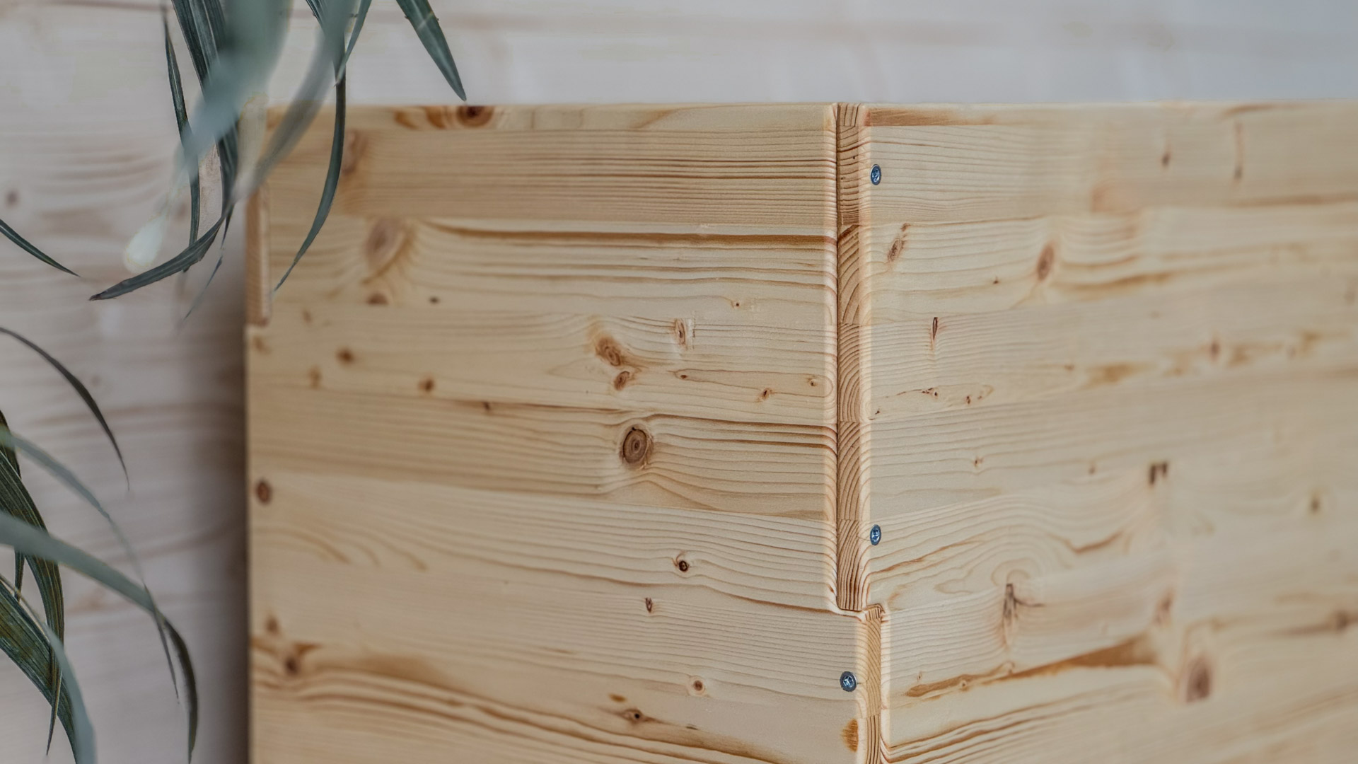 Cestino per differenziata in legno naturale inserito in un elegante ambiente domestico.