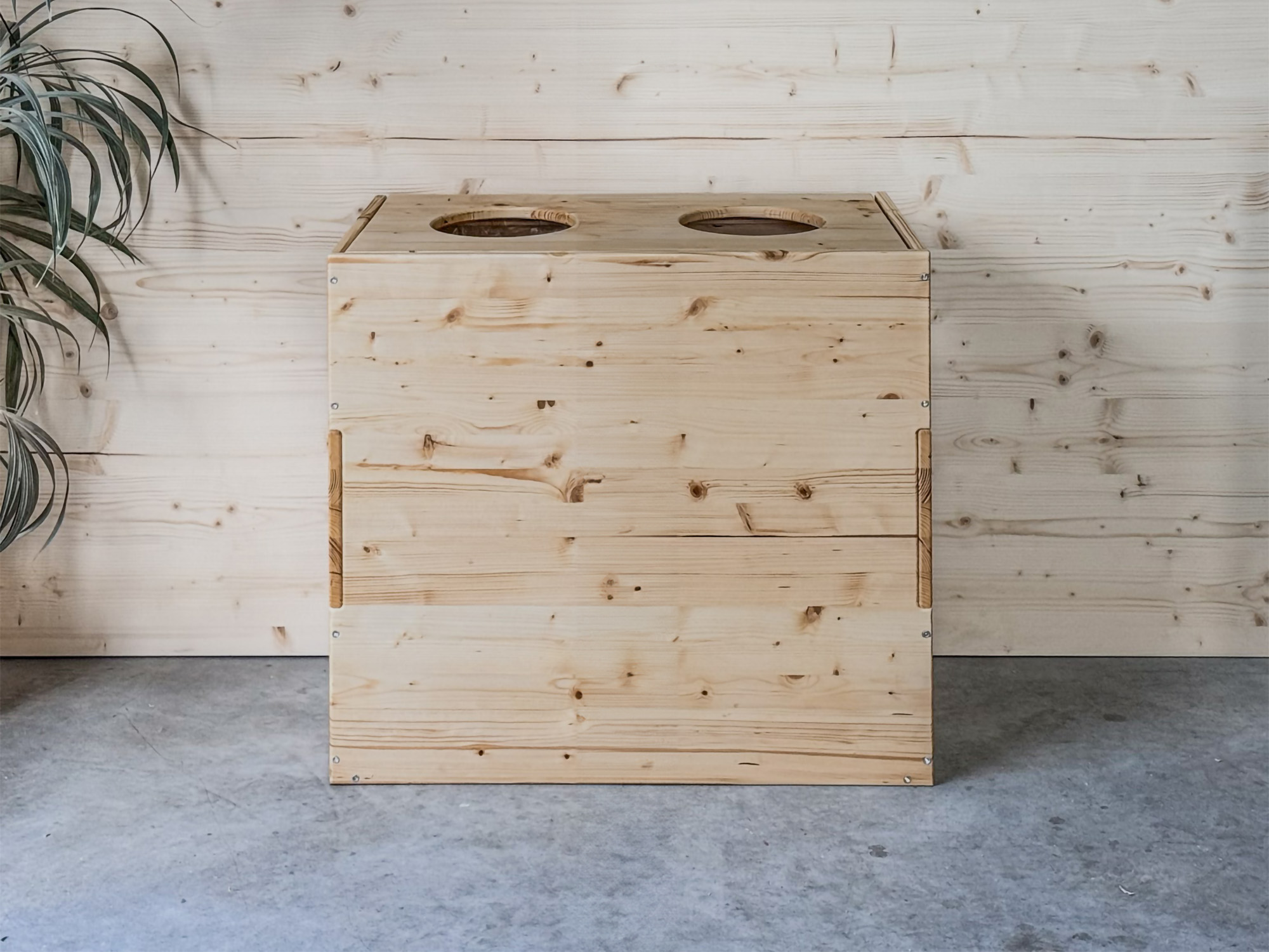 Cestino per differenziata in legno naturale inserito in un elegante ambiente domestico.